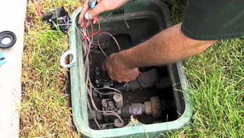 a SeaTac sprinkler repair tech is checking the valve box